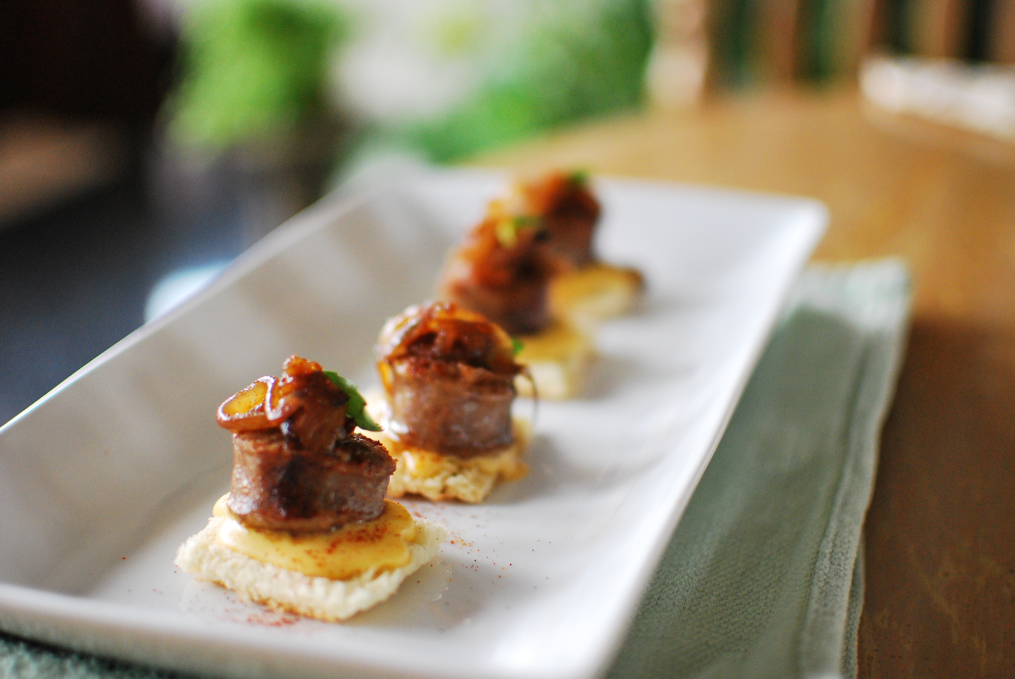 Grilled Bratwurst Appetizer with Dijon-Cheddar Fondue, Caramelized Onions, and Basil