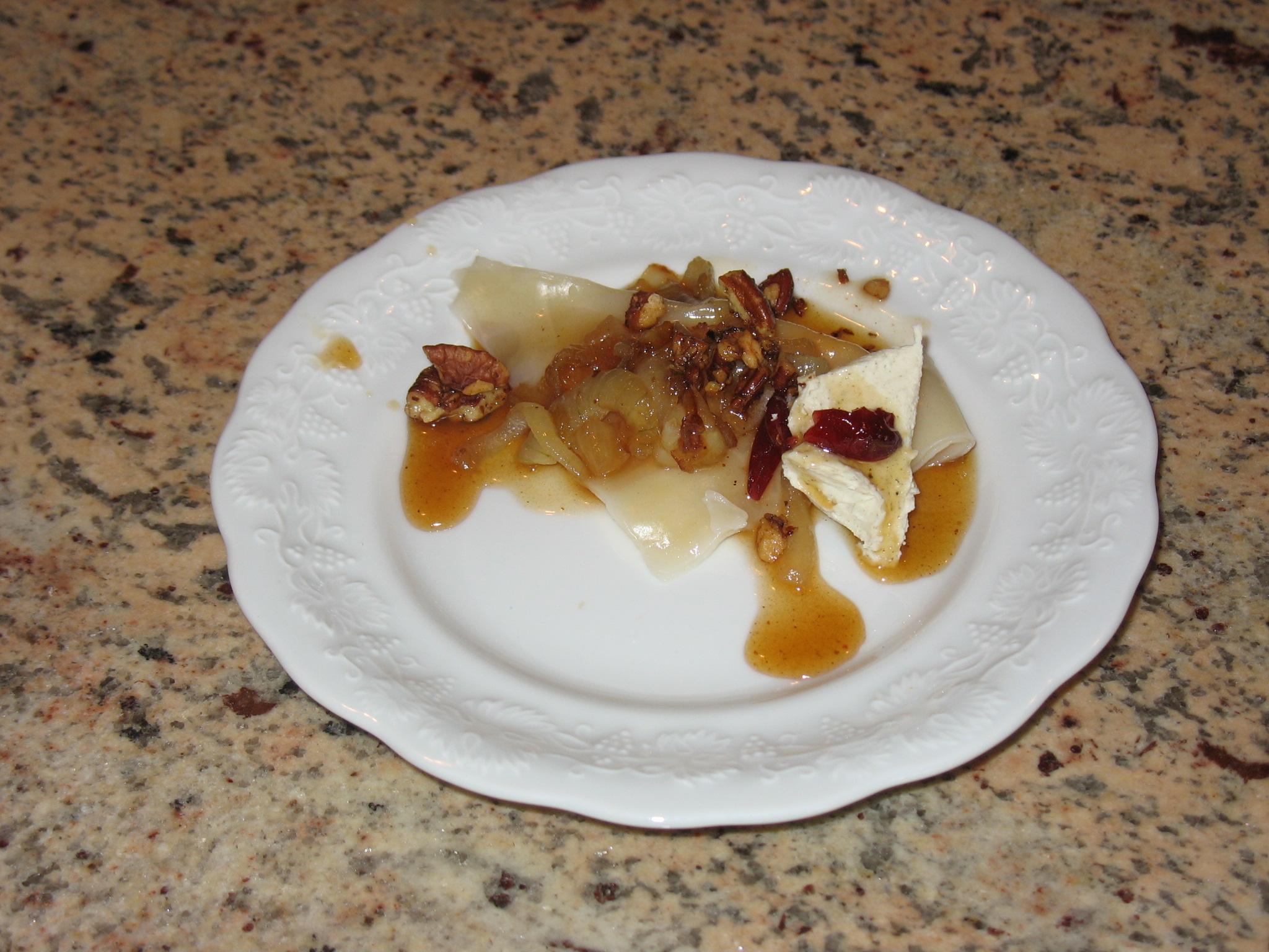 Butternut Squash ravioli with caramelized onions, browned pecans, soaked cranberries, and apple cider reduction