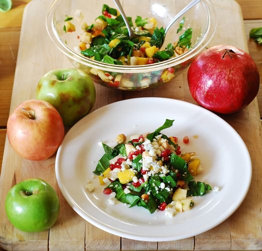 Chopped salad with apples, pears, mango, spinach, hazelnuts, and pomegranates