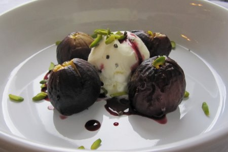 Roasted figs in a red wine cardamom-infused reduction with vanilla ice cream